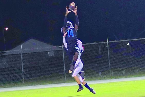 Interlachen’s Kemontae Nixon goes high over Taylor defender Dakota Febus to catch a 30-yard pass in the second quarter. (RITA FULLERTON / Special to the Daily News)