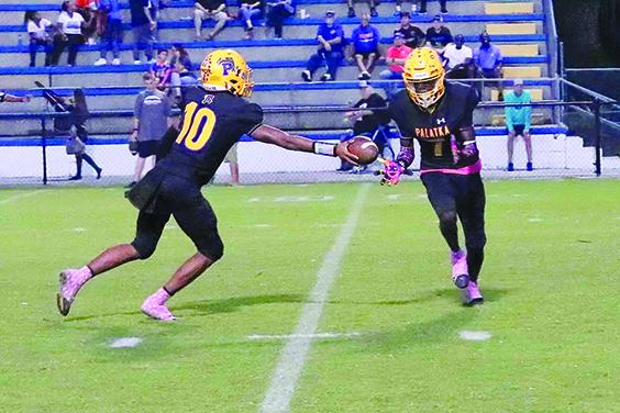 Palatka’s Cartaveon Valentine (right) gets the handoff from quarterback Tommy Offord and goes 22 yards with the first-half play. (RITA FULLERTON / Special to the Daily News)
