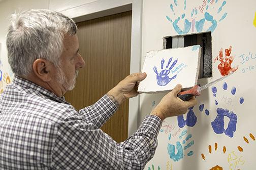 Submitted by David Chudzik. Wayne Placona, HCA Florida Putnam's director of facilities services, cuts out Kadance Branam's handprint to save for her family. 