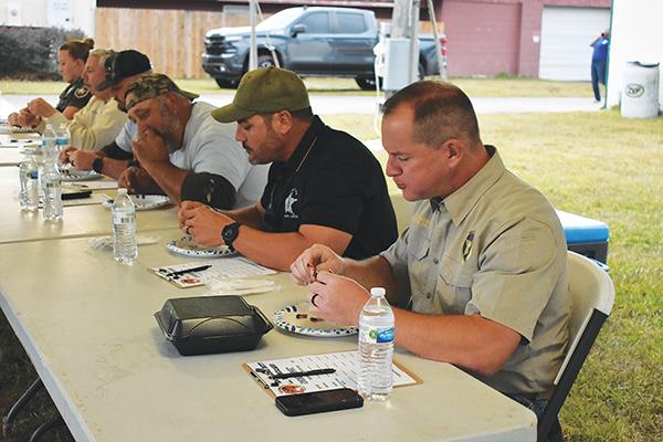 BRANDON D. OLIVER/Palatka Daily News – Sheriff Gator DeLoach, right, and others taste-test ribs in the Anything Butt contest Friday evening at the Ten-24 Foundation fundraiser. 