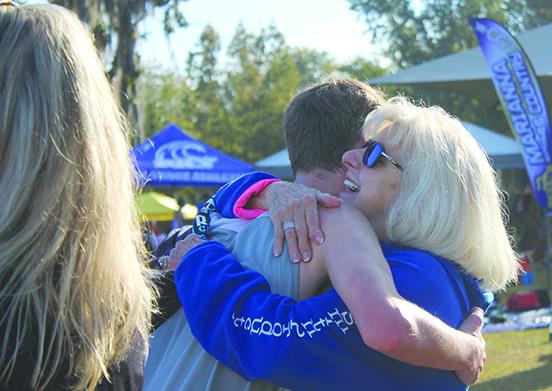 Peniel Baptist Academy runner Reed Rion gets a hug from his grandmother, Hazel Hinton, after he finished his race at the Region 2-1A championship at Alligator Lake Park in Lake City on Thursday. (MARK BLUMENTHAL / Palatka Daily News)