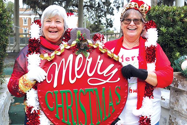 TRISHA MURPHY/Palatka Daily News Jeri Eubanks, left, and Holly Harris hold a large ornament as they look forward to next week’s Palatka Christmas Parade, where they will be two of the grand marshals.