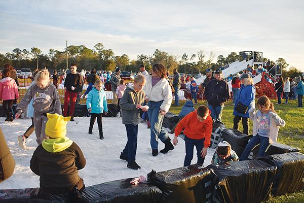 BRANDON D. OLIVER/Palatka Daily News – Children play in snow pits while others careen down ice slides Friday during the second annual Snow Day at the Putnam County Fairgrounds in East Palatka.