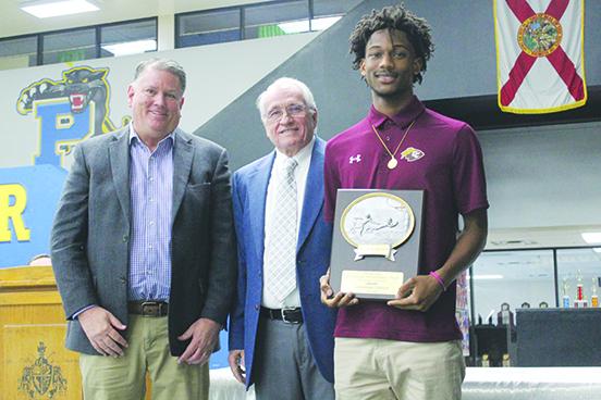 Crescent City’s Lentavius Keenon stands with his trophy honoring him as Putnam County’s player of the year in football at the Jim McCool All-County football team banquet on Dec. 11 at Palatka Junior-Senior High School. Posing with Keenon are (from left) Chris Gent, the public affairs manager at Georgia Pacific, and Jim McCool, who coached Palatka High’s program from 1983-2003. (MARK BLUMENTHAL / Palatka Daily News)