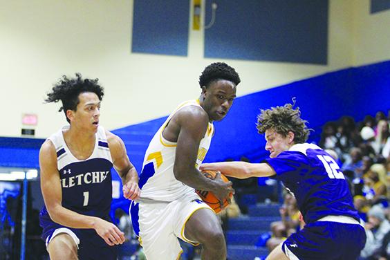 Palatka’s Trenton Williams (middle) looks to take the ball to the basket while guarded by Neptune Beach Fletcher’s Anthony Vaglienti (1) and Sam Perry during Wednesday’s game in the Jarvis Williams Holiday Classic. (MARK BLUMENTHAL / Palatka Daily News)