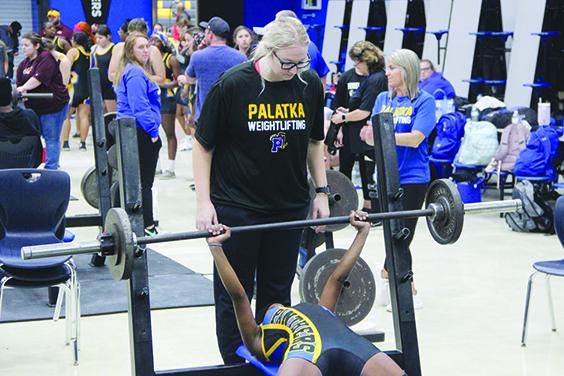With her head coach, Katelynn Smith, spotting her, Palatka’s Ymira Passmore competes in the bench press at 101 pounds Wednesday. (COREY DAVIS / Palatka Daily News)