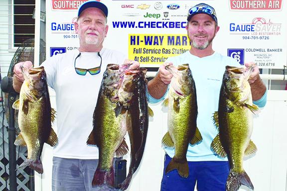 Brett Bollinger (left) and Justin Atkinson hold up their winning creel from the Putnam Paws Open Benefit Bass Tournament. (GREG WALKER / Daily News correspondent)