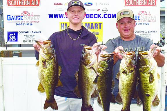 Son and father Parker (left) and Lee Stalvey hold up their second-place creel on Dec. 2. (GREG WALKER / Daily News correspondent)