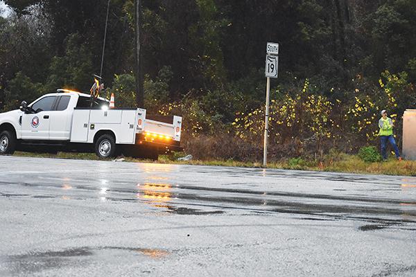 BRANDON D. OLIVER/Palatka Daily News – A Putnam County employee works on equipment at the intersection of State Road 19 and Silver Lake Drive on Tuesday during the storm that pounded the area with rain.