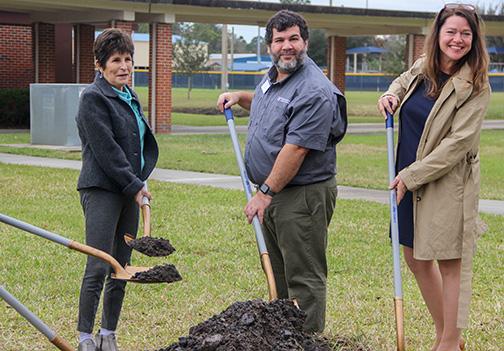 SARAH CAVACINI/Palatka Daily News. Palatka Mayor Robbi Correa, local horticulture agent Julio Perez, and Keep Putnam Beautiful Executive Director Nicole Grace lift dirt Friday as they prepare to plant a live oak tree to celebrate Arbor Day at St. Johns River State College in Palatka. 