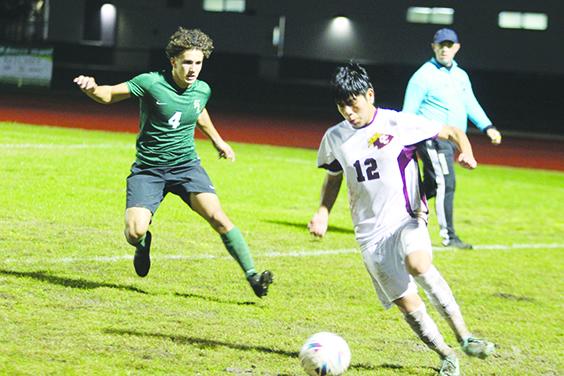 Crescent City’s Elkiin Perez controls the ball as Daytona Beach Father Lopez’s Joseph Abrantes closes in on him during the Jan. 18 game. (MARK BLUMENTHAL / Palatka Daily News)