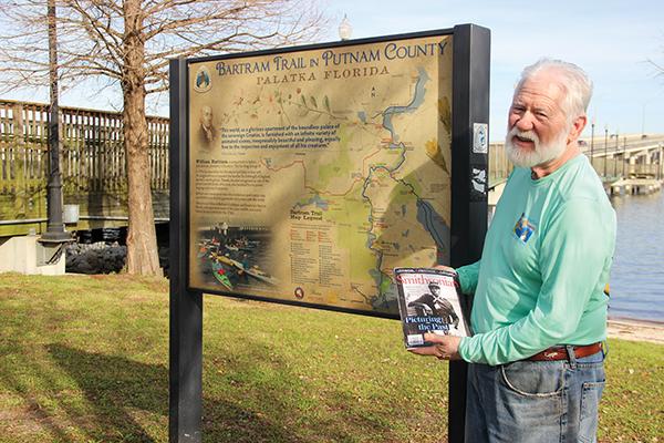 SARAH CAVACINI/Palatka Daily News - Bartram Trail Society of Florida President Sam Carr holds the January-February issue of Smithsonian Magazine while standing in front of a Bartram Trail marker in Palatka.