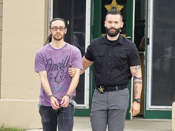 Photo courtesy of the Putnam County Sheriff's Office – A Putnam County Sheriff's Office detective walks suspect Dalton Richard Babcock to be booked into the jail earlier this month.