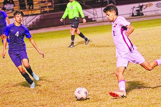 Crescent City’s Jeremiah Carbajal gets set to kick the ball away as Pierson Taylor’s Emmanuel Benitez looks to make a play during the second half of Wednesday’s District 9-3A championship match won by the Raiders, 3-0. (RITA FULLERTON / Special to the Daily News)