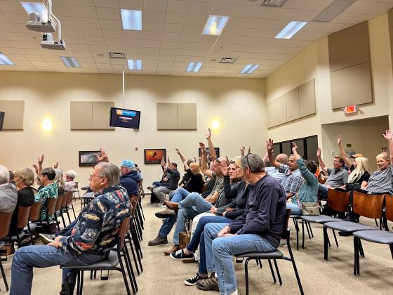 SARAH CAVACINI/Palatka Daily News. Meeting attendees who want to speak against a proposed borrow pit in Florahome raise their hand March 20 during a Zoning Board of Adjustment meeting.