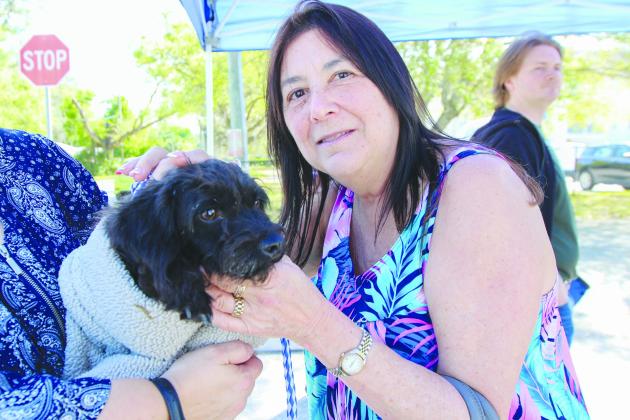 St. Augustine resident Mindy Esbin shows her new dog, Sadie, some love Friday during an adoption event where 41 dogs found new homes. (SARAH CAVACINI / Palatka Daily News)