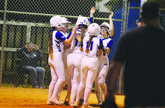 Peniel Baptist Academy softball teammates surround Lexi Peacock (16) after she hit a three-run home run over the left field fence against Gainesville Countryside Christian Thursday. (MARK BLUMENTHAL / Palatka Daily News)