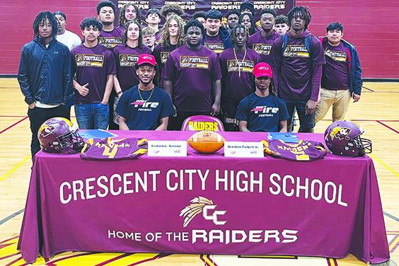 With the support of their football teammates behind them, Crescent City’s Lentavius Keenon (sitting, left) and Brandon Padgett (sitting, right) smile after signing letters of intent to play football and attend classes at Southeastern University in Lakeland. (Submitted photo)