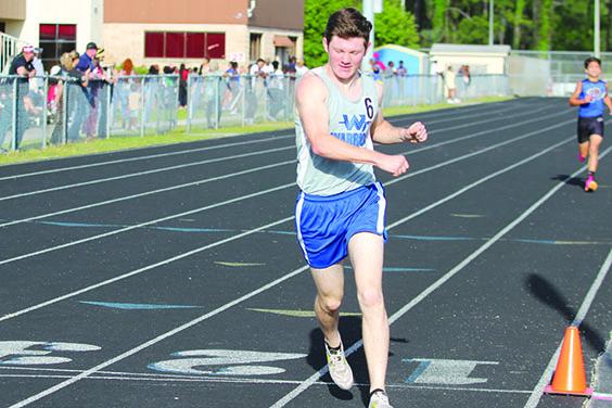Peniel Baptist Academy’s Caleb Baker punches the air after winning the 1,600-meter run, becoming the first Peniel athlete to win a county meet event. (MARK BLUMENTHAL / Palatka Daily News)