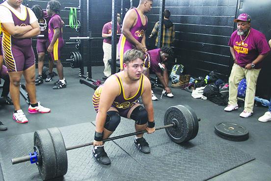 With head coach Troy Henry (right) looking on, Crescent City 219-pound weightlifter Jacob Westberry gets set to make a clean-and-jerk lift attempt Wednesday against host Interlachen. (COREY DAVIS / Palatka Daily News)