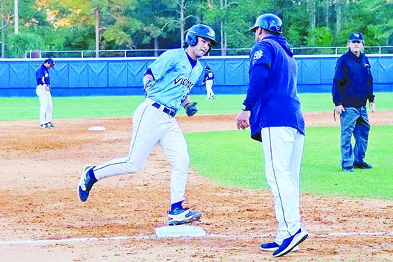 St. Johns River State College’s Lucas Phelps gets congratulations from third-base coach Matt Kennedy after hitting a three-run home run in the fourth inning against Seminole State. (RITA FULLERTON / Special t the Daily News)