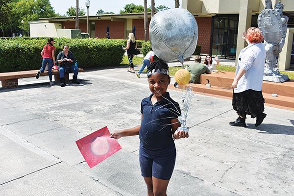 BRANDON D. OLIVER/Palatka Daily News – A child with a moon balloon has fun during the college's eclipse viewing party Monday afternoon.