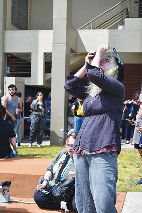 BRANDON D. OLIVER/Palatka Daily News – A woman takes pictures of the eclipse by pressing her phone's camera lens against her eclipse glasses.