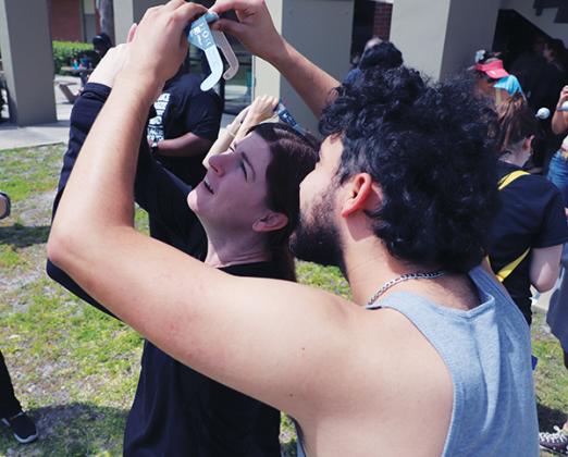 Photo submitted by Susan Kessler – A woman and man look at the eclipse during the viewing party at SJR State on Monday.