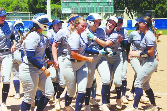 Olivia Hansen (with helmet on) is mobbed by happy St. Johns River State College softball players after hitting her grand slam in the fourth inning of her team's 10-6 game one victory over Lake-Sumter State. (MARK BLUMENTHAL / Palatka Daily News)