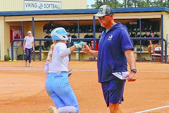 St. Johns River State College softball coach Joey Pound congratulates Caylee Elder as she rounds third base after hitting a second game home run Saturday against Pasco-Hernando State. (RITA FULLERTON / Special to the Daily News)