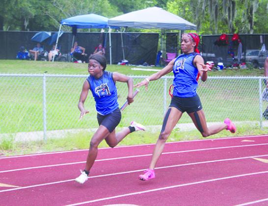 Palatka's Jahzara Fields (right) hands the baton off to teammate Ymira Passmore during the Panthers' winning 4x100 relay on Thursday at the District 5-2A championship at Alachua Santa Fe High School. (MARK BLUMENTHAL / Palatka Daily News)