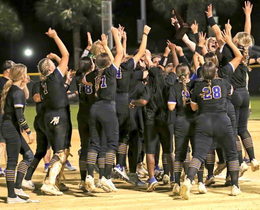 Palatka softball coach Katelynn Smith (holding the trophy) and her players celebrate winning the District 3-3A championship, 12-7, over Keystone Heights Thursday, the first district title for Palatka since 2009. (RITA FULLERTON / Special to the Daily News)