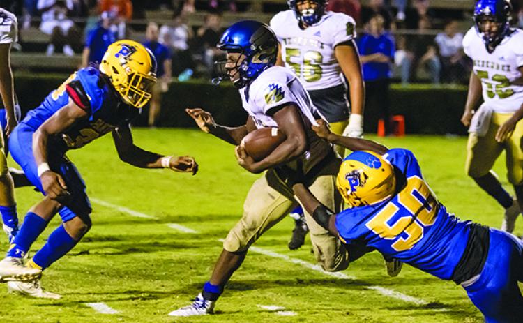 Palatka defenders David Williams (34) and Tyree Johns (50) combine for a stop of Menendez quarterback King Benford (11) in the second half of their Aug. 23 game. (FRAN RUCHALSKI / Palatka Daily News)