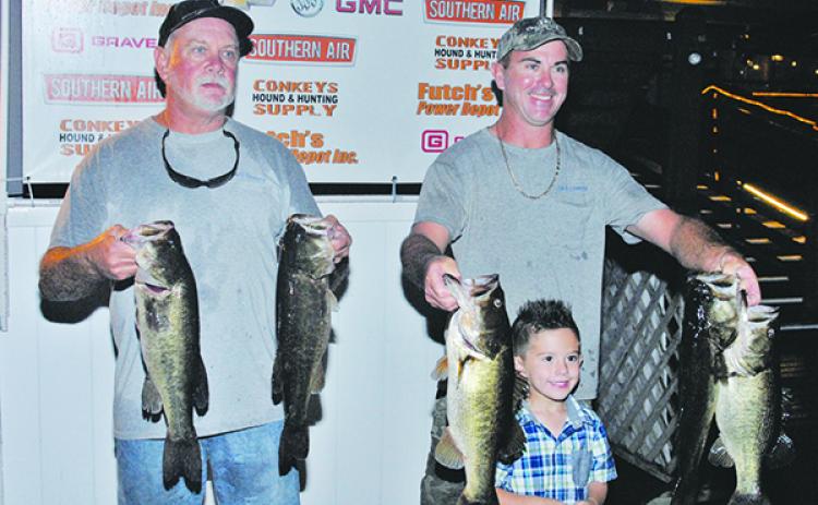 From left, Brett Bollinger and Justin Atkinson hold up their winning fish. (GREG WALKER / Special to the Daily News)