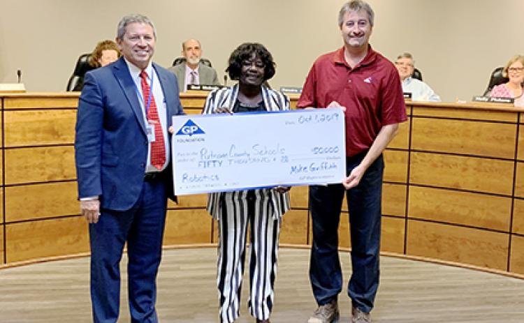 School district and Georgia-Pacific officials stand with the $50,000 check the company presented to the district.