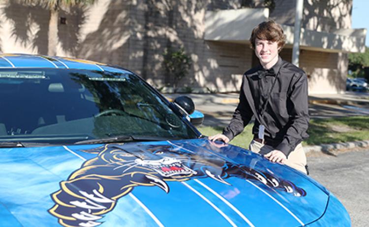 Curtis Moore stands next to the car for which he designed the exterior art.
