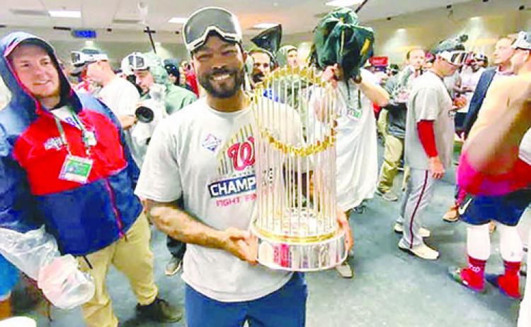 Howie Kendrick holds the World Series trophy after Game 7.