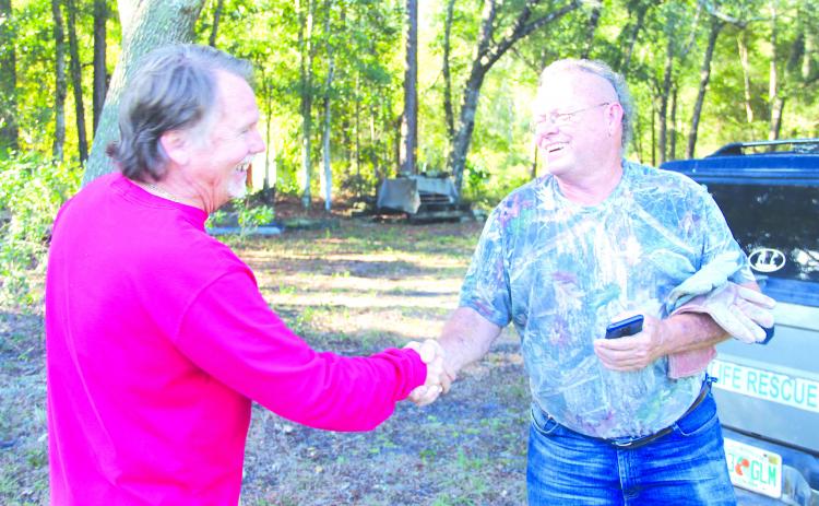 Steve Morgan shakes hands with animal rescuer John Fields.