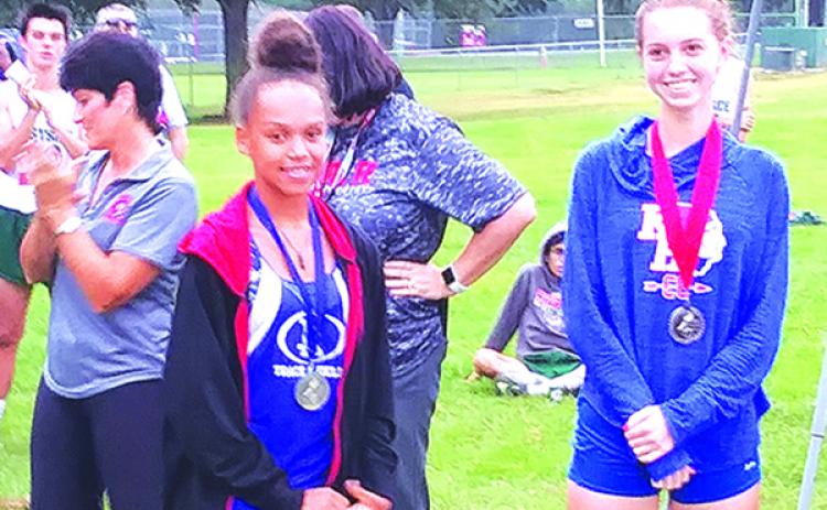 Interlachen’s Kierra Chauncey, left, smiles with her first-place medal draped around her neck next to second-place finisher Camryn Williams of Keystone Heights after winning the 2018 District 5-2A title. (MARK BLUMENTHAL / Palatka Daily News)