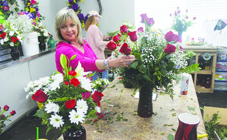Flowers by Melanie owner Melanie Wells arranges a bouquet of red roses in a Valentine’s Day arrangement Monday, beginning one of the busiest weeks of the year for her business. For a full story, see Page 5A.
