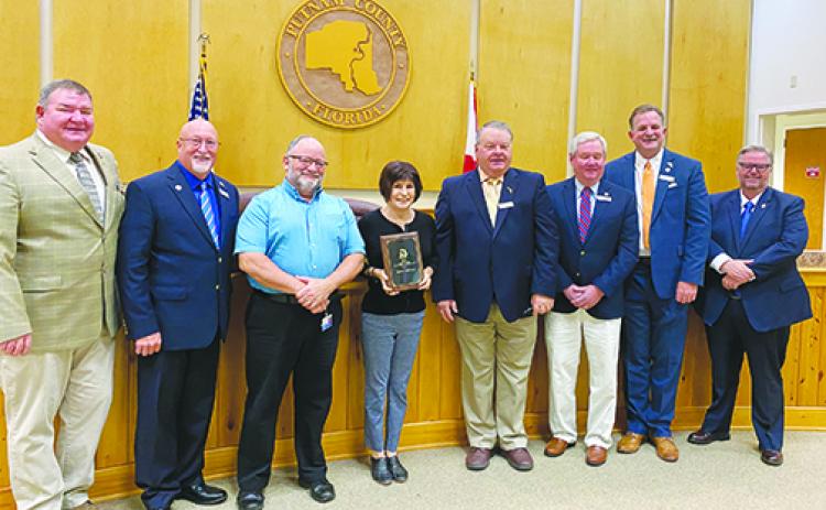 Representatives from the Waterways and Trails Committee were presented with a plaque Tuesday at the Board of County Commissioners meeting to honor Palatka becoming a Trail Town last year.