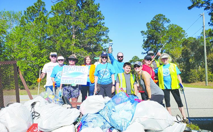 A group shows off their garbage collection from Keep Putnam Beautiful’s Countywide Cleanup on Saturday along County Road 207A west of Hastings.