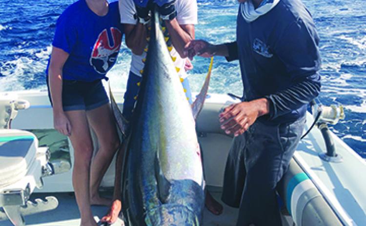 Palatka High School Principal J.T. Stout, center, shows off the 6-foot long tuna he caught recently in the Pacific Ocean alongside his wife, Kristen, and Capt. Pepe Jaramillo on the ship Ole’ Ole’. (Submitted to the Daily News)