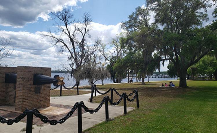 In the distance, a family enjoys a picnic under the shade along the riverfront in Palatka on a sunny day. Temperatures are expected to reach into the 90s this week in Putnam County.