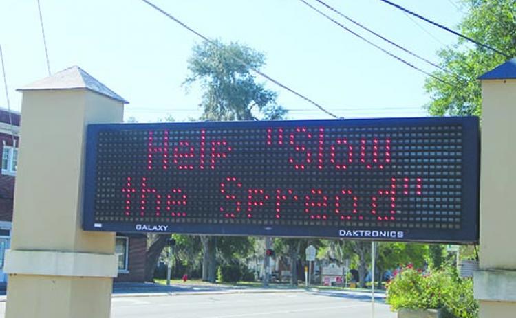 A sign leading into Crescent City’s business district reads “Help ‘Slow the Spread’” to remind residents coronavirus is still a threat to public health. 