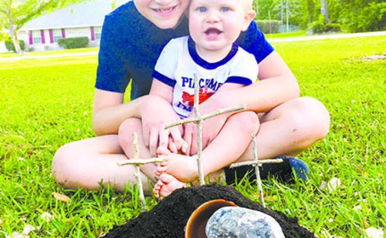Truett Duke, 8, and his brother, Hudson, 14 months, are pictured with the Resurrection Garden the family puts together every Easter.