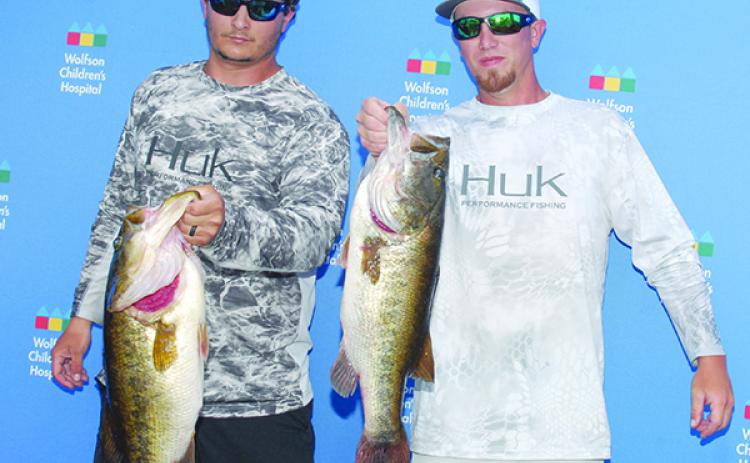 Wolfson Children’s Hospital Bass Tournament winners Cole Kite, left, and Trey Owen hold up their two largest bass during the tournament last May 18. (GREG WALKER / Special To The Daily News)