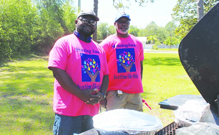 Pastor James Mathews and Steven Holmes cook ribs for Putnam Community Medical Center employees Friday. 