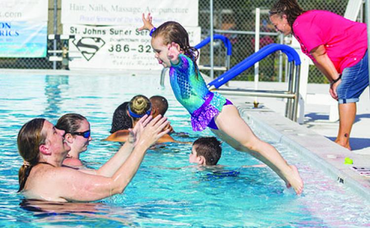 Breleigh Smith jumps in the pool into the arms of her mother, Paige Smith, last year at the Putnam Aquatics Center. 