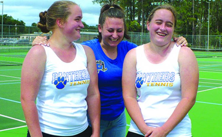 Grace Roebuck, right, laughs at something Palatka High School girls tennis teammate Emma Coyle, center, says, as Grace’s twin sister, Ruth, smiles in the moment earlier in the month. (MARK BLUMENTHAL / Palatka Daily News)